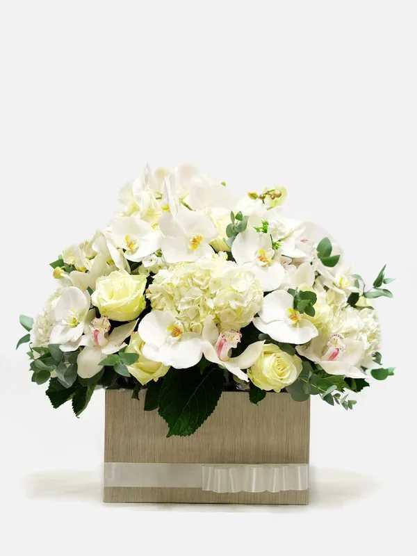 White orchids and pale roses in a square box with ribbon