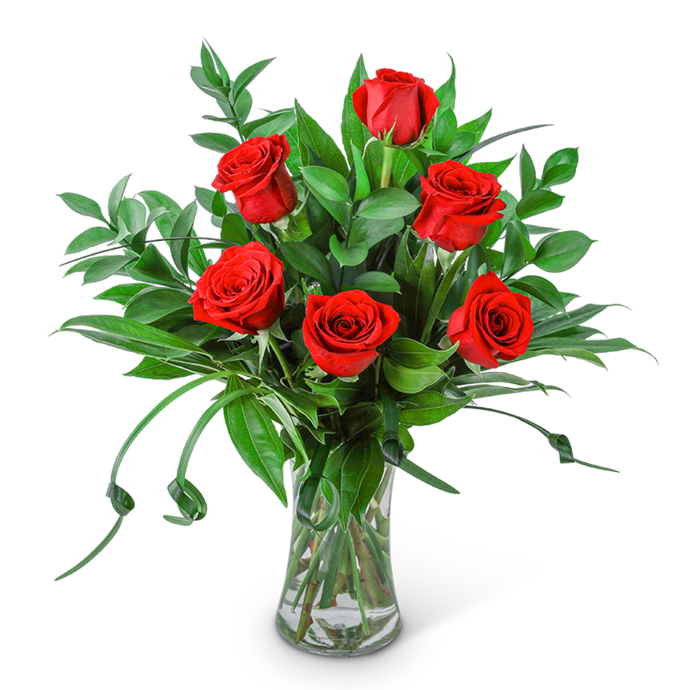 Red roses arranged in a clear glass vase with greenery