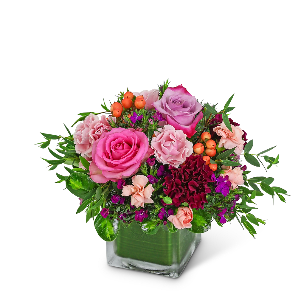 Pink and purple rose arrangement in a square glass vase