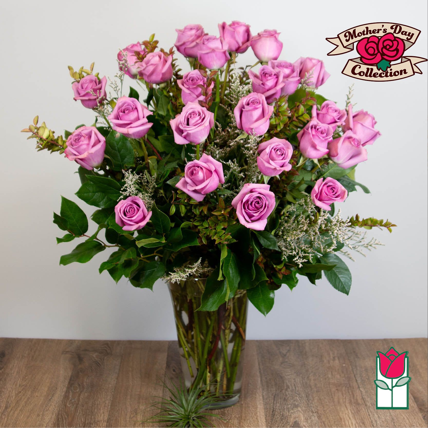 Pink roses arranged in a clear glass vase with greenery