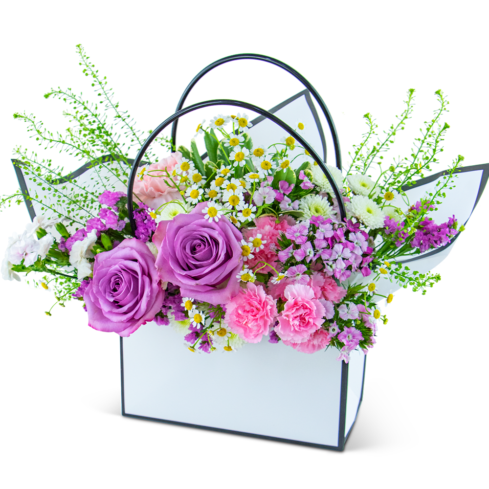 Bouquet of purple roses and pink mixed flowers in a white handled box