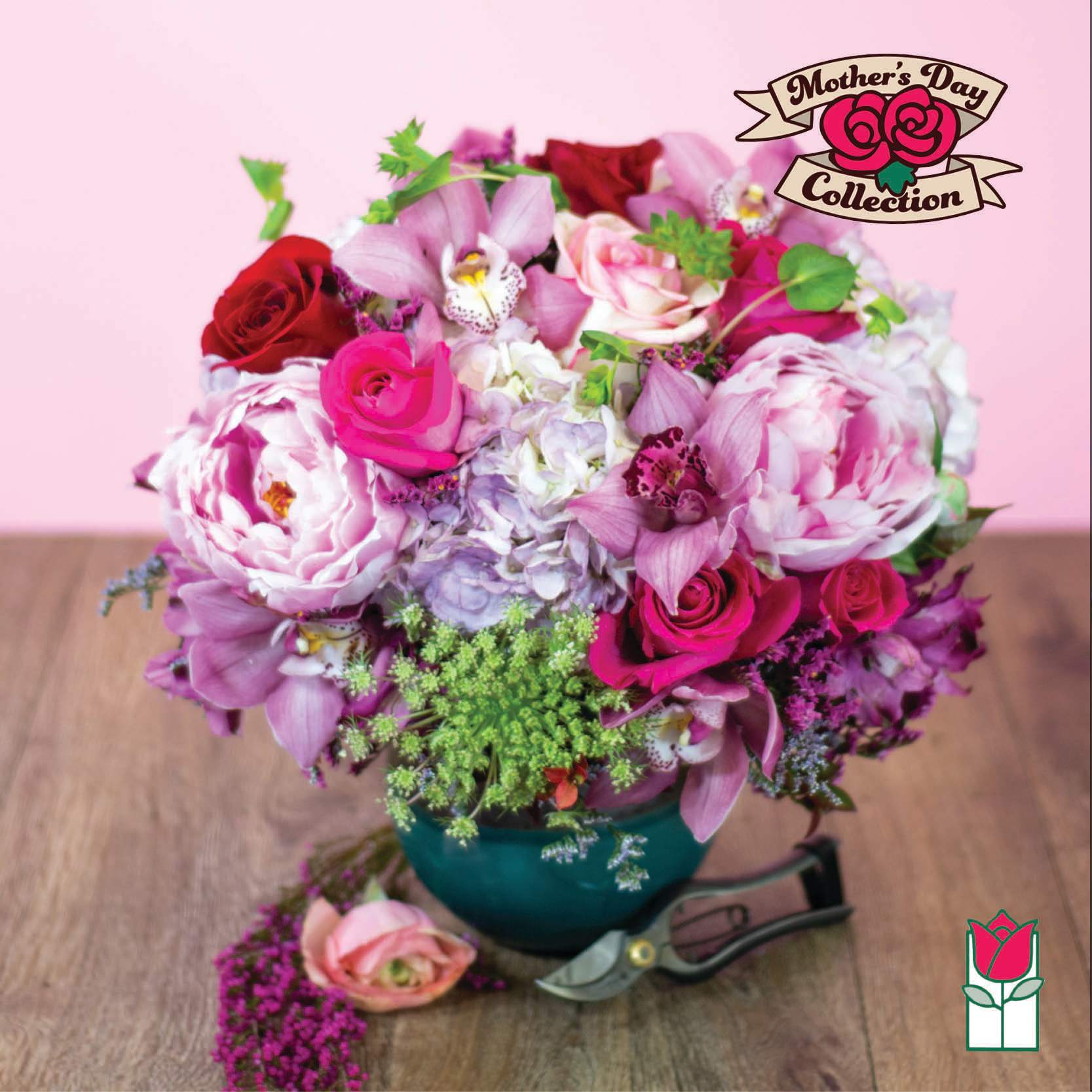 Pink and red mixed flower arrangement in a teal vase