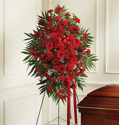 Red Standing Spray - Vivid red carnations, gerbera daisies and roses with white fillers and lush greenery on a standing spray; formal sympathy arrangement with a red ribbon cascade.