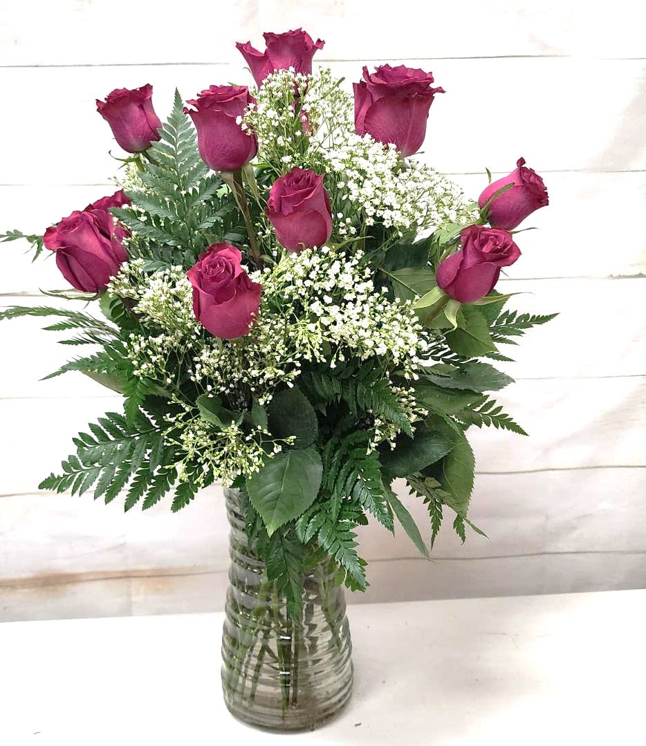 Berry Purple Rose Masterpiece - Experience the elegance and beauty of the New Berry Rose Dozen Masterpiece. This stunning arrangement features twelve exquisite berry-hued roses, each carefully selected and artfully arranged to create a breathtaking display.  Key Features:  Premium Quality Roses: Each rose is handpicked for its vibrant berry hue and exceptional quality, ensuring a long-lasting and beautiful arrangement.  Elegant Presentation: The roses are expertly arranged to showcase their natural beauty, making this bouquet a true masterpiece.  Perfect for Any Occasion: Ideal for anniversaries, birthdays, holidays, or as a special gift to express love and admiration.  Dozen Roses: Includes twelve stunning berry-hued roses, offering a full and impressive display.  Stylish Vase: The bouquet is presented in a stylish vase that complements the rich colors of the roses, adding a touch of sophistication to any setting.  Celebrate a special occasion or brighten someone's day with the New Berry Rose Dozen Masterpiece. This elegant arrangement is sure to leave a lasting impression and convey your heartfelt sentiments.
