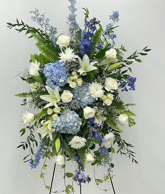 Blue and White Standing Spray - White and pale blue hydrangeas, roses, lilies and delphinium with green accents - a serene, elegant standing spray ideal for memorials and sympathy displays.
