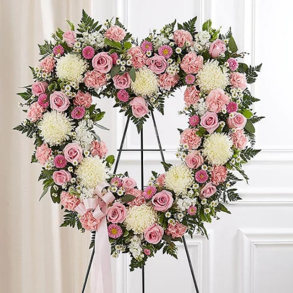 Pink and White Heart Spray - Pink roses, pale carnations, white chrysanthemums and daisies form a dense heart-shaped tribute framed in green, finished with a pale pink ribbon-formal, sentimental memorial spray.