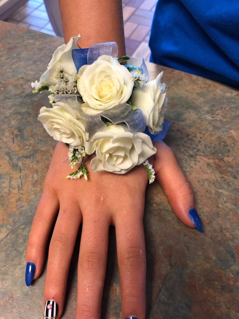 WHITE ROSE CORSAGE WITH BLUE RIBBON - An example of a corsage with white roses and blue ribbon. Other colors may be available based on color/ribbon availability. Please text Darlene at 419-636-7813 with a picture of your dress so we can match the corsage to the dress