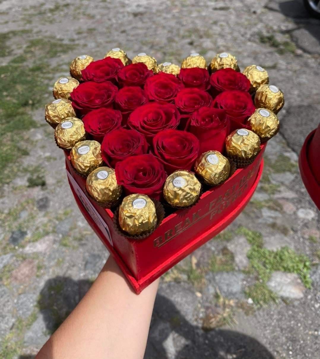 Heart-shaped box of red roses and gold-wrapped chocolates