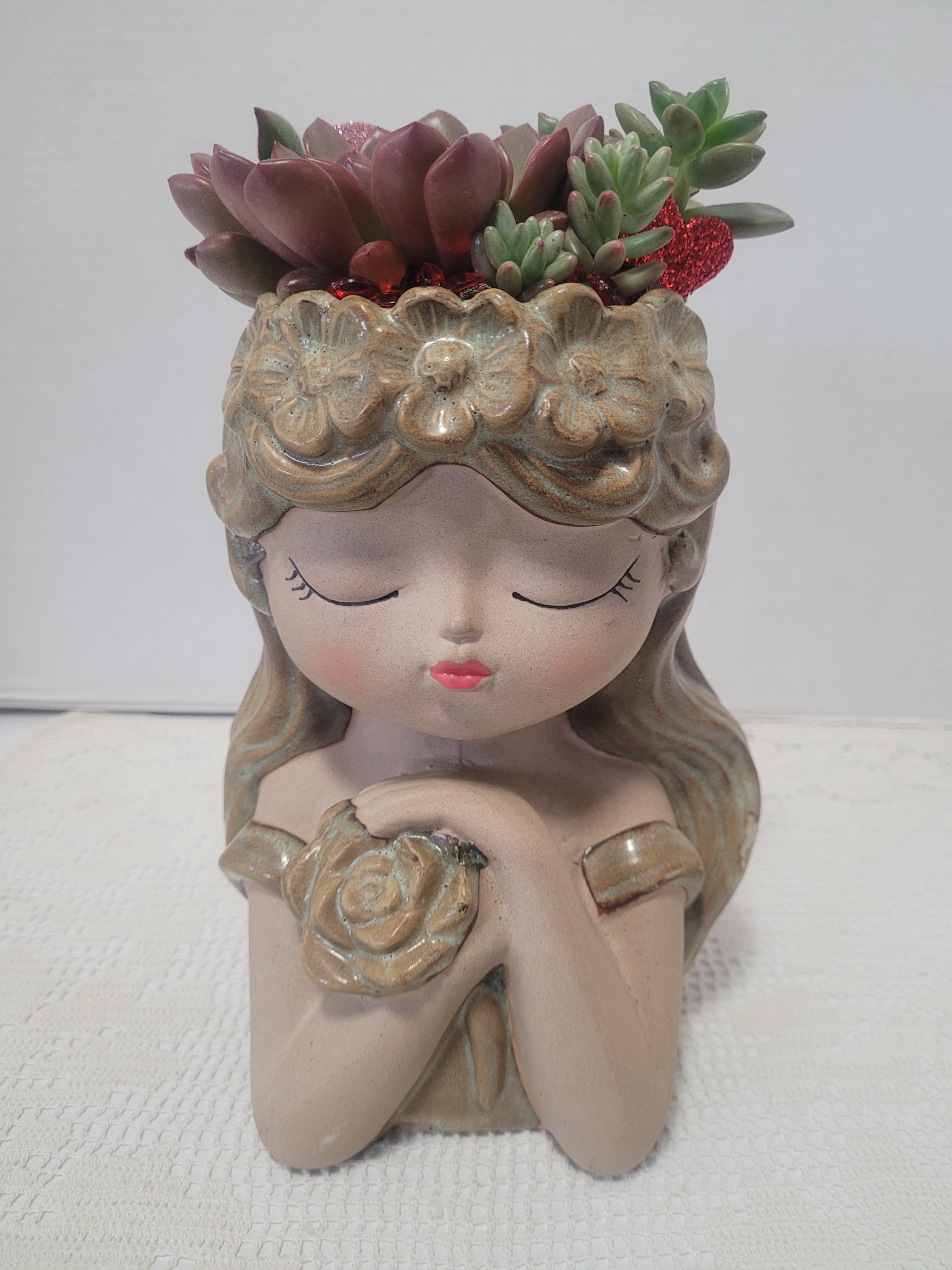 Ceramic girl planter with succulent arrangement on top