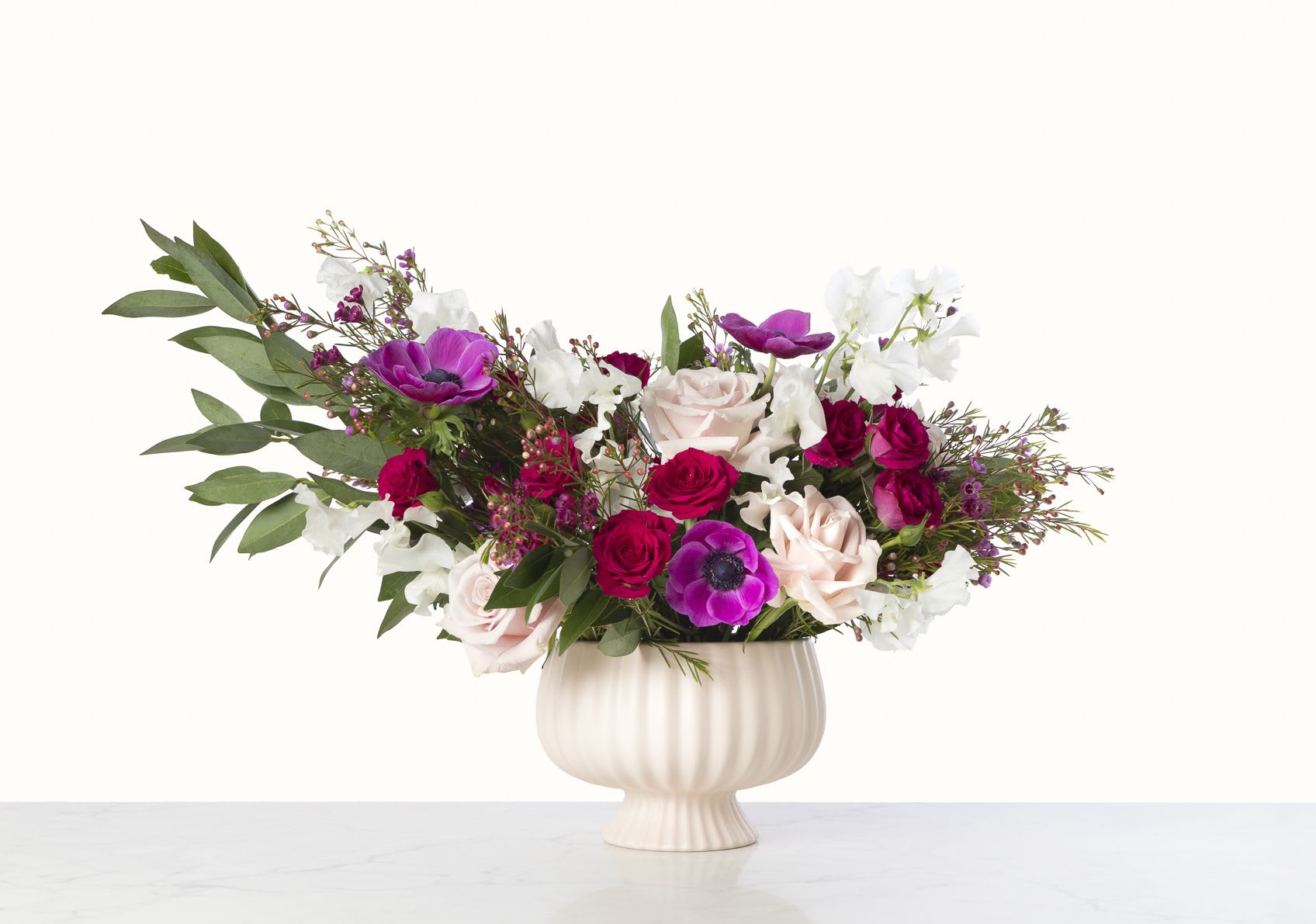 Pink Sapphire - Make the ultimate declaration of love with this opulent arrangement of fluttering sweet peas, vivid anemones, and romantic roses!  Blooms in all shades of pink are abundantly displayed in a light blush ceramic compote -- and will be sure to delight your one-and-only.  Arrangement measures approximately 12" tall by 16" wide.