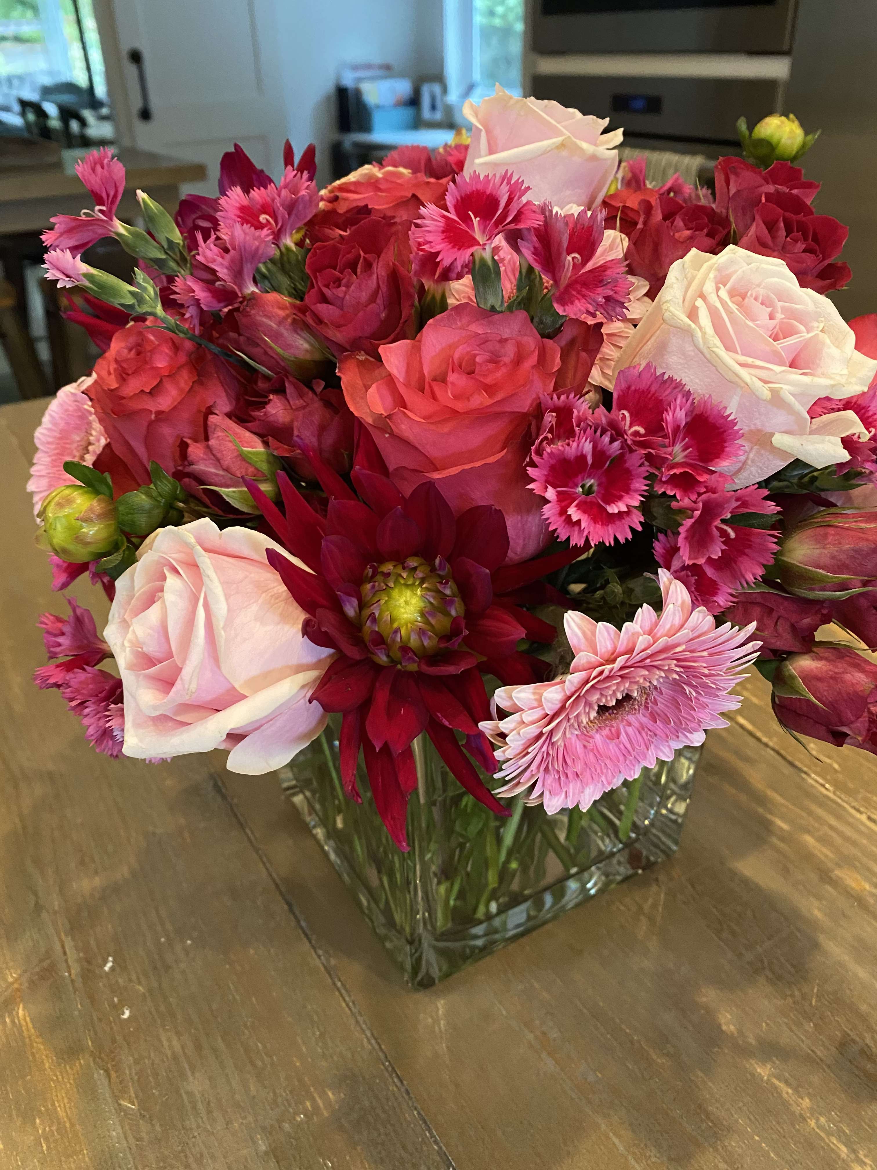 Pink and red mixed bouquet in a clear square vase