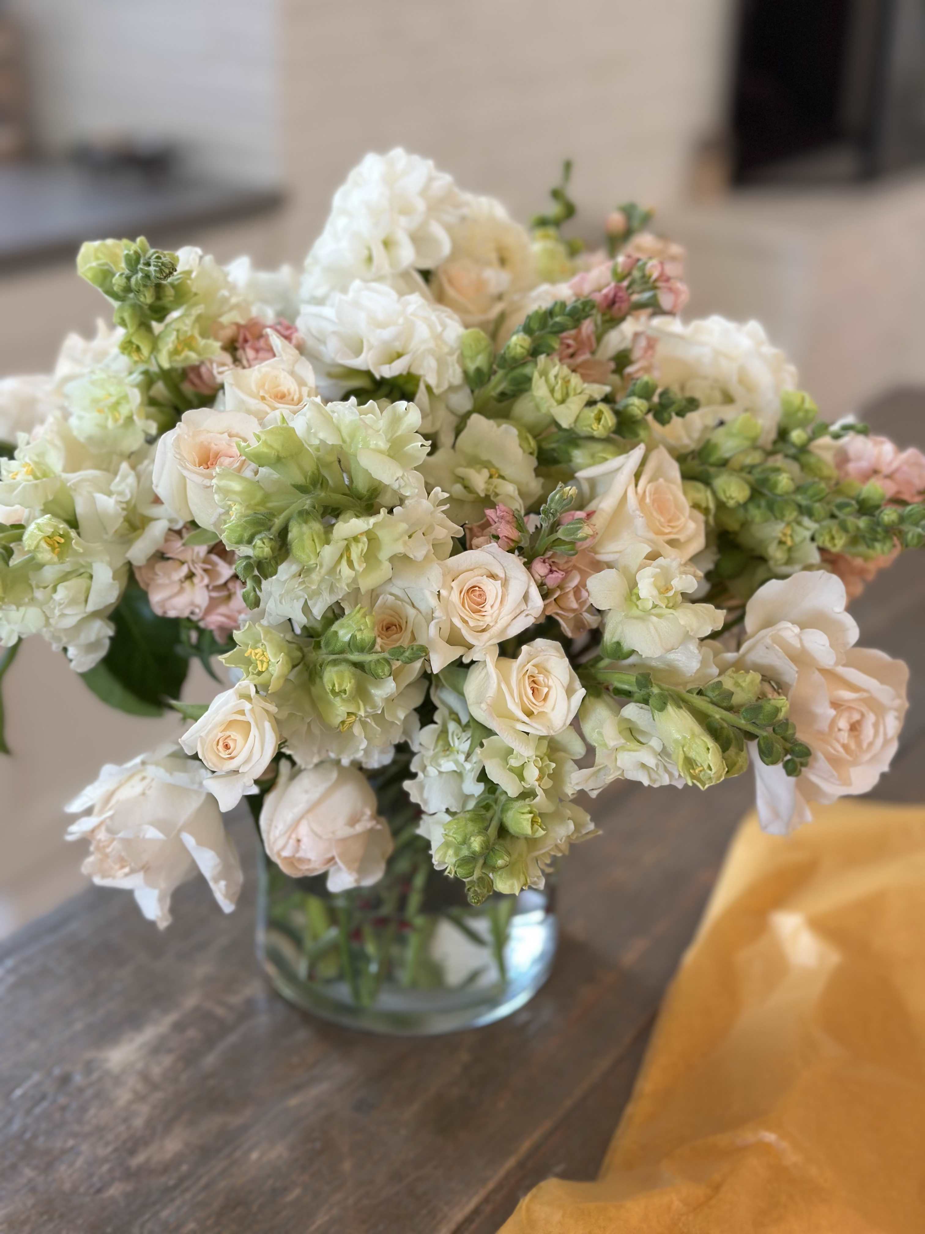 Bouquet of pale roses and white snapdragons in a glass vase