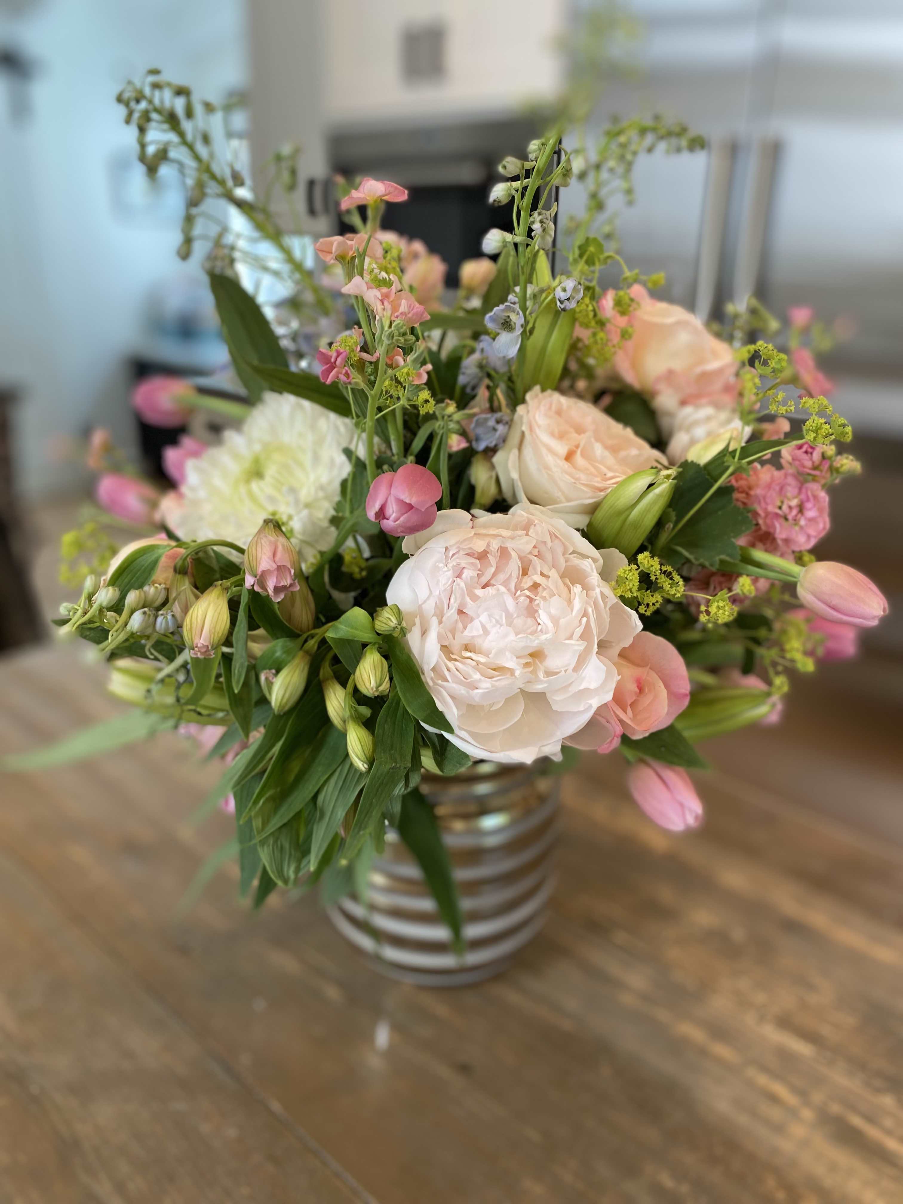 Pink and white mixed bouquet in a striped glass vase