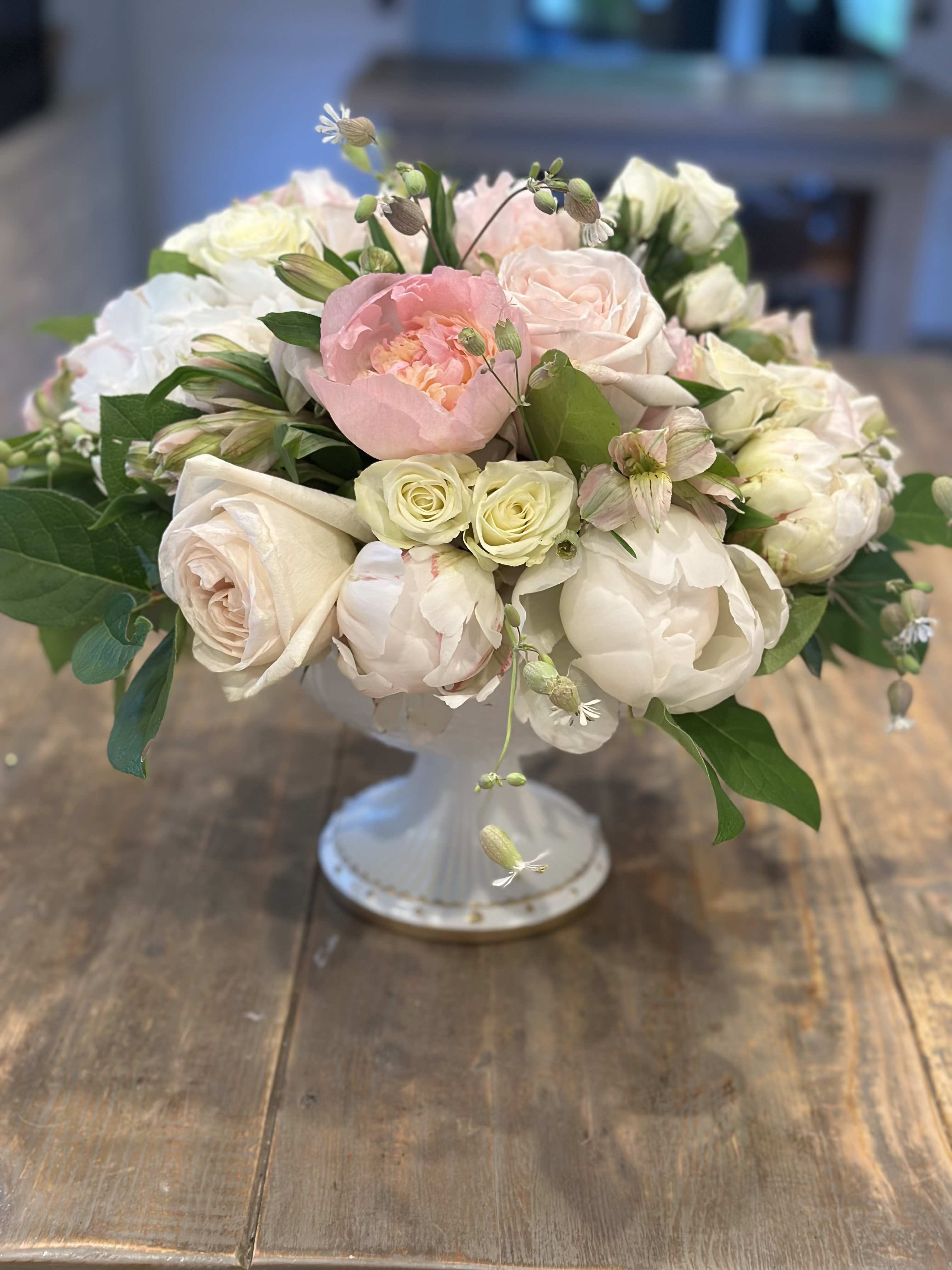 Blush and white bouquet of roses and peonies in a white vase