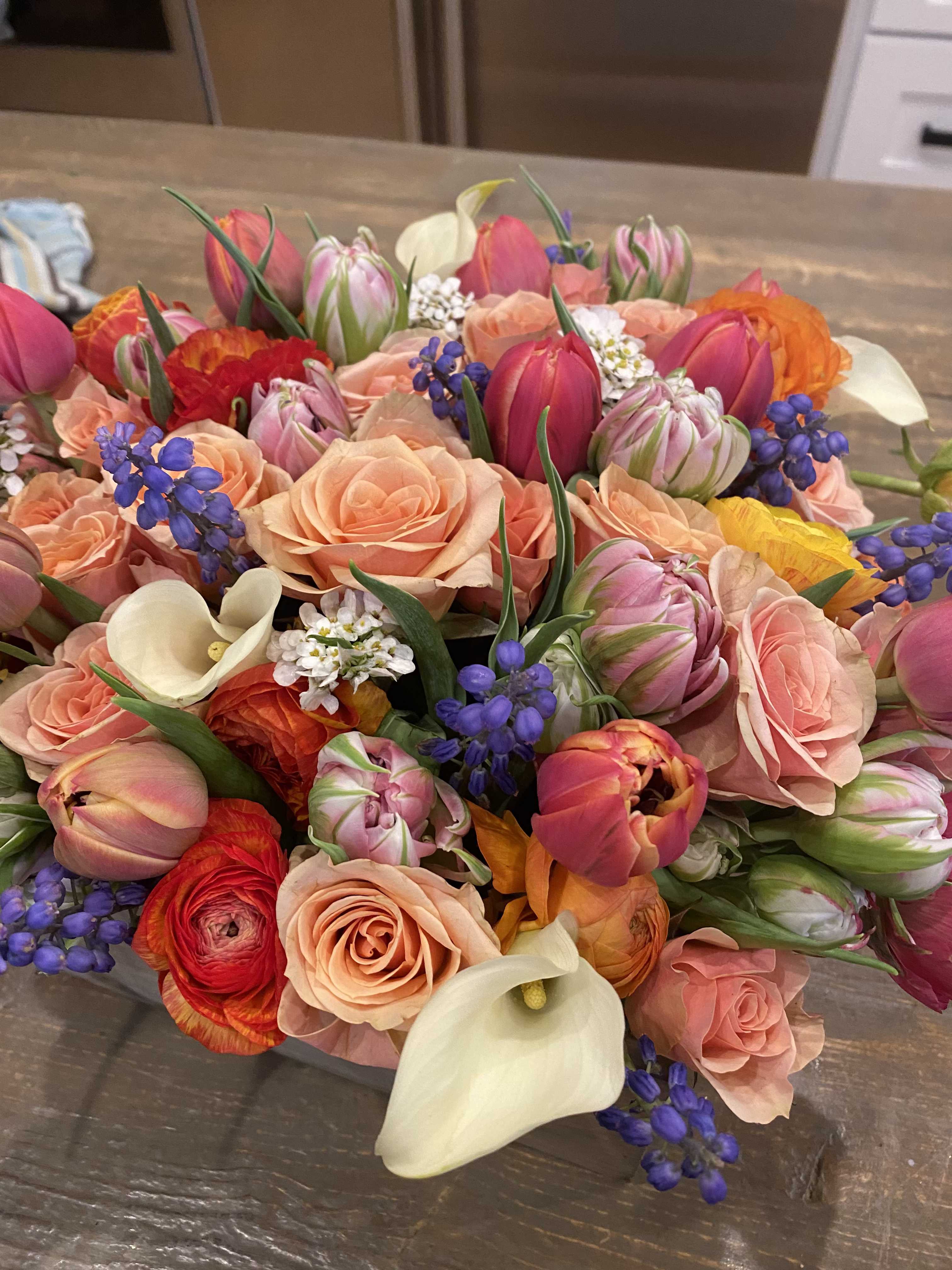 Mixed bouquet of pink roses, tulips, calla lilies, and purple accents