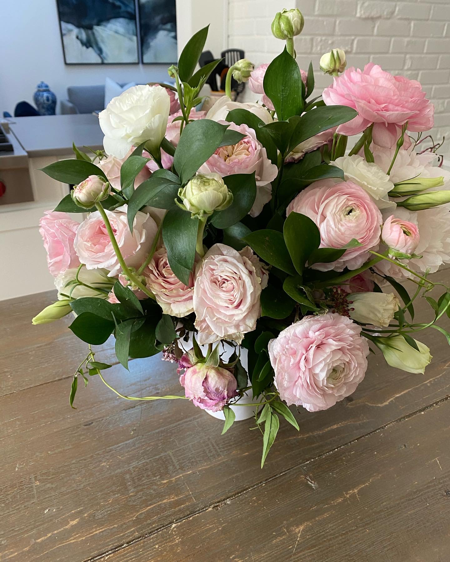 Pink and white ranunculus bouquet in a low white vase