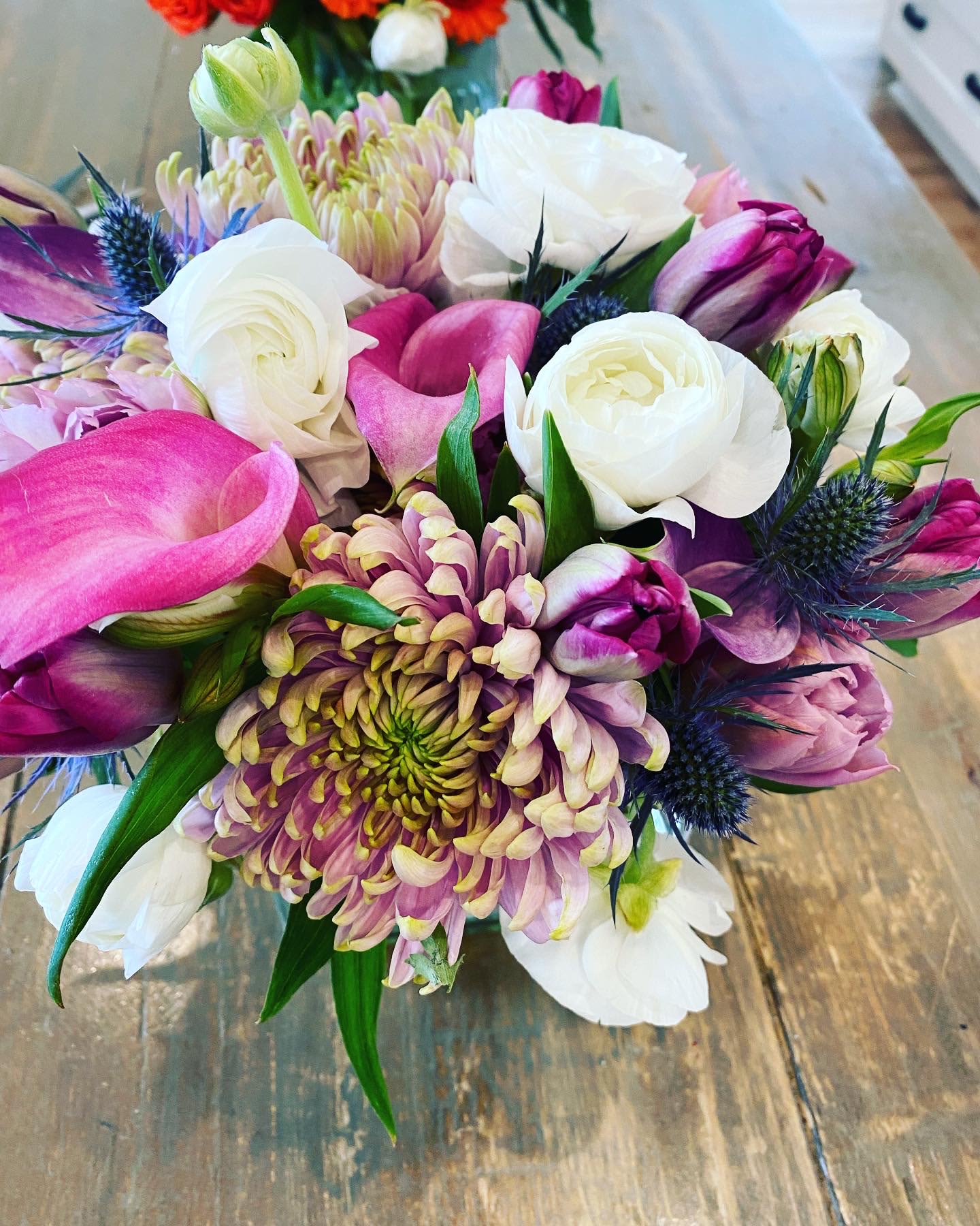 Bouquet of pink, white, and purple flowers with spiky blue accents