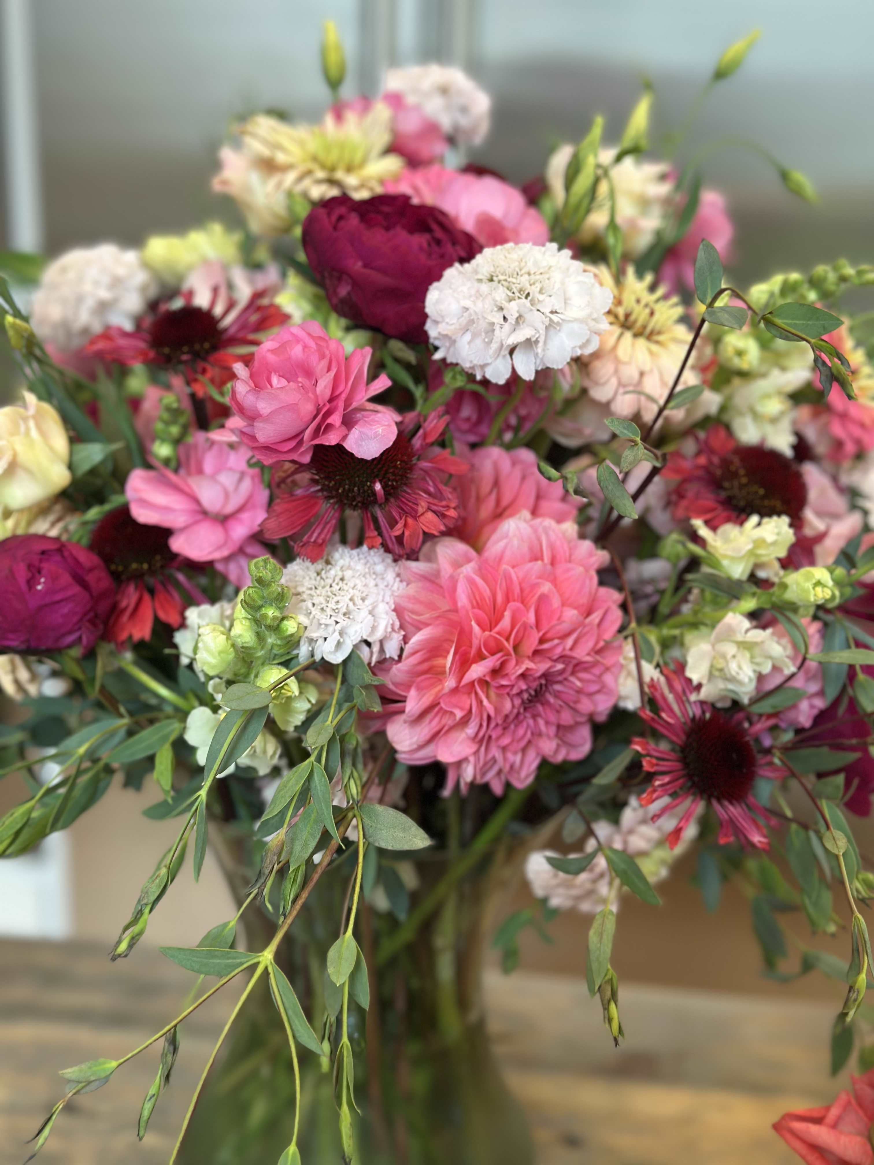 Mixed bouquet of pink, white, and burgundy flowers in a vase