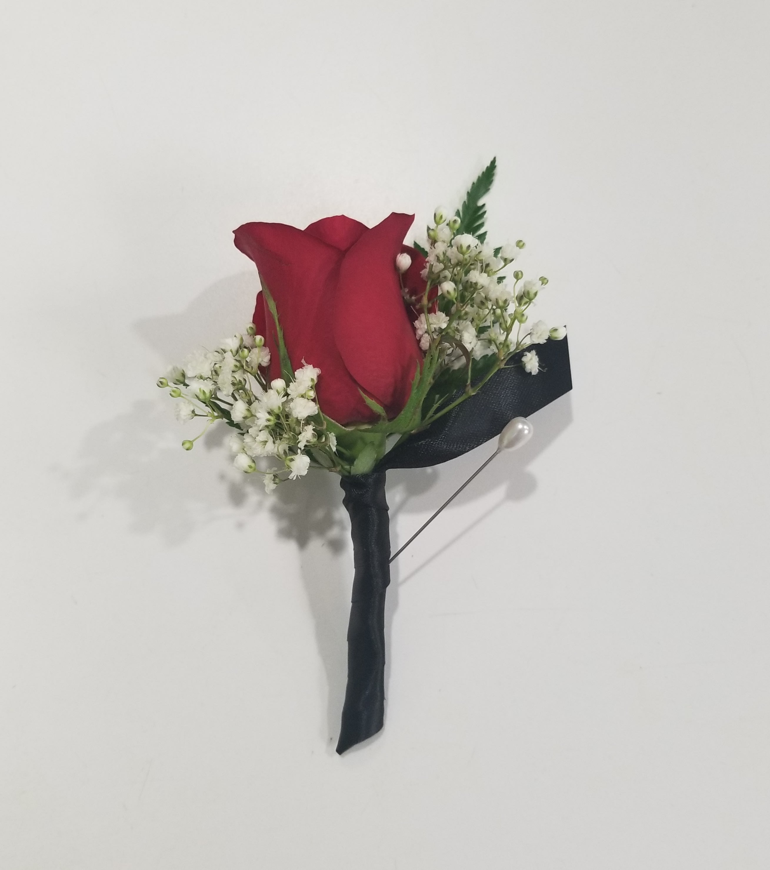 Red rose boutonniere with white baby's breath and black ribbon