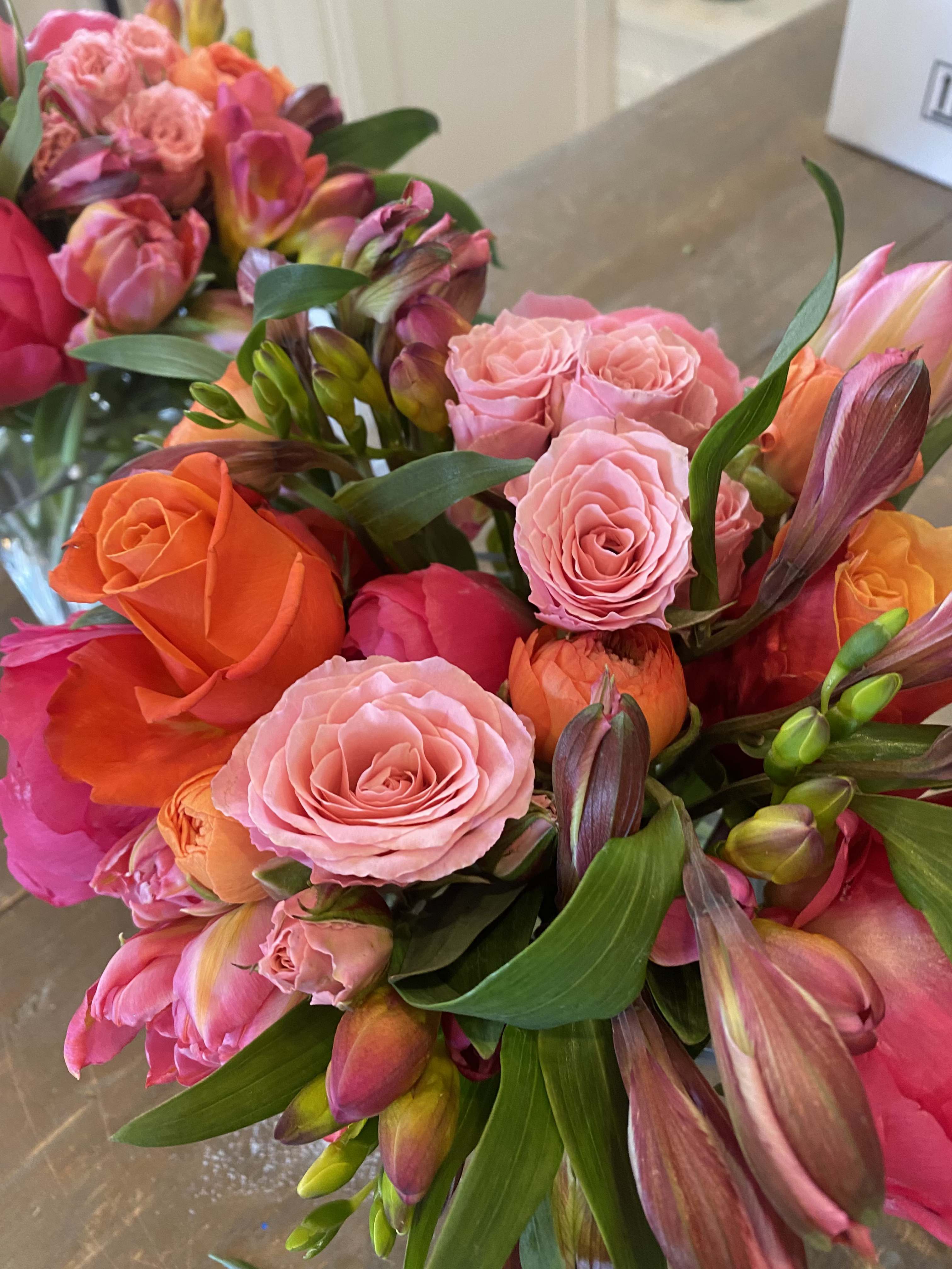 Bouquets of pink, orange, and coral roses with mixed blooms