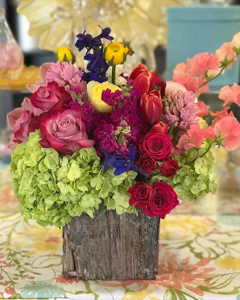 Colorful mixed flower arrangement in a rustic wooden container