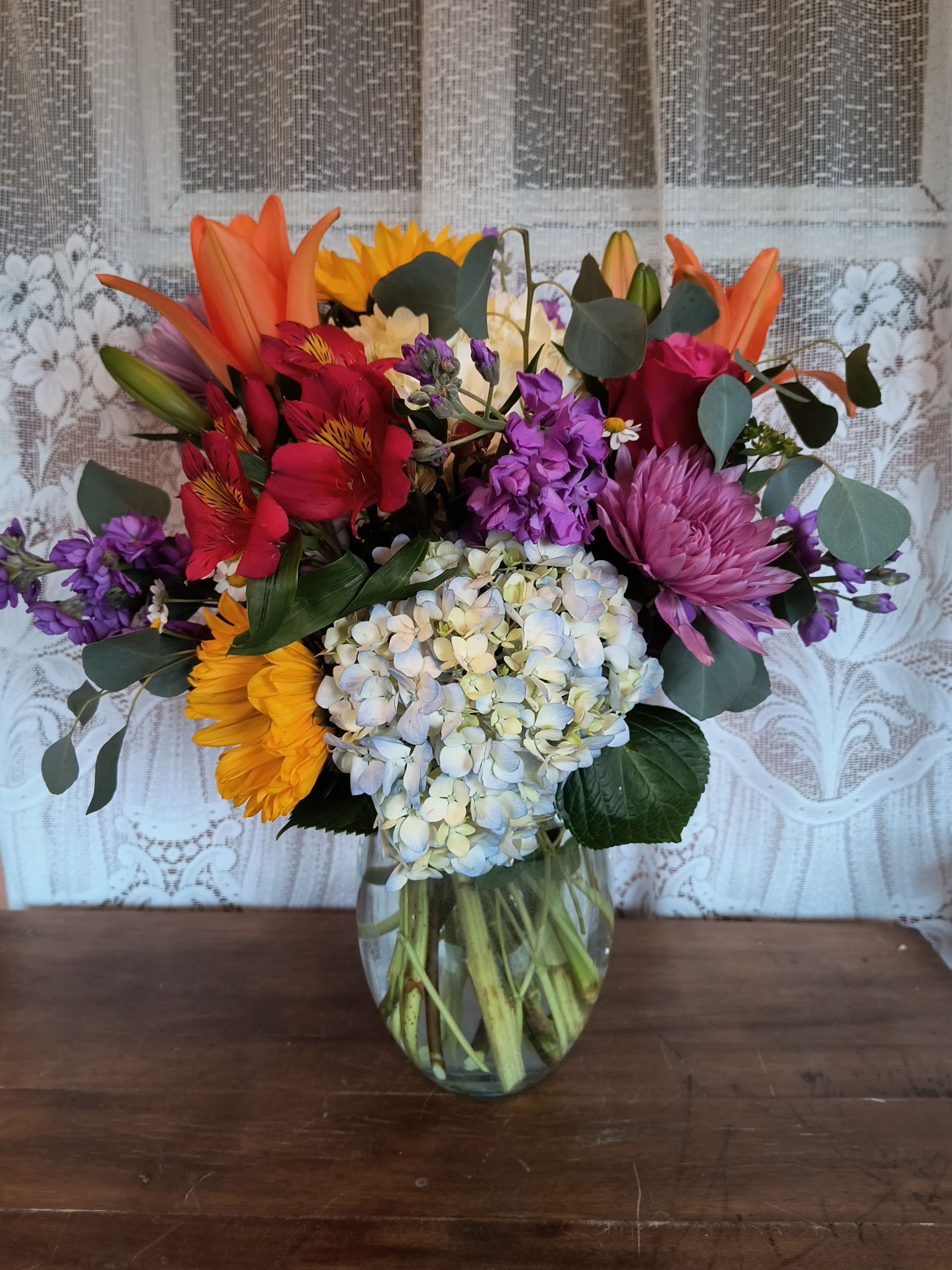 Mixed bouquet of colorful flowers in a clear glass vase