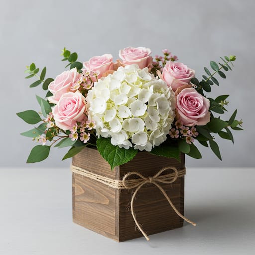 Pink roses and white hydrangea in a wooden box