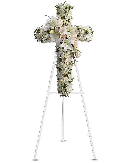 Divine Light - Beautiful flowers such as crème roses, white spray roses, oriental lilies, stock, leptospermum, cushion and button spray chrysanthemums on an easel-mounted standing cross. 36"H x 22"W