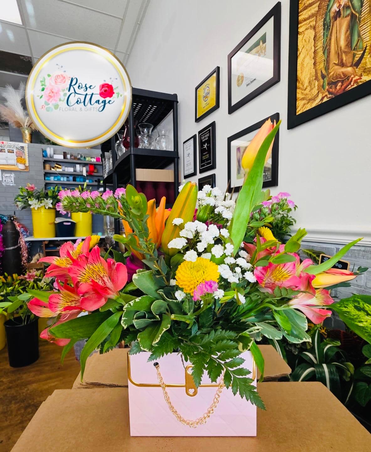 Mixed bouquet in a pink gift box with pink, yellow, and white flowers