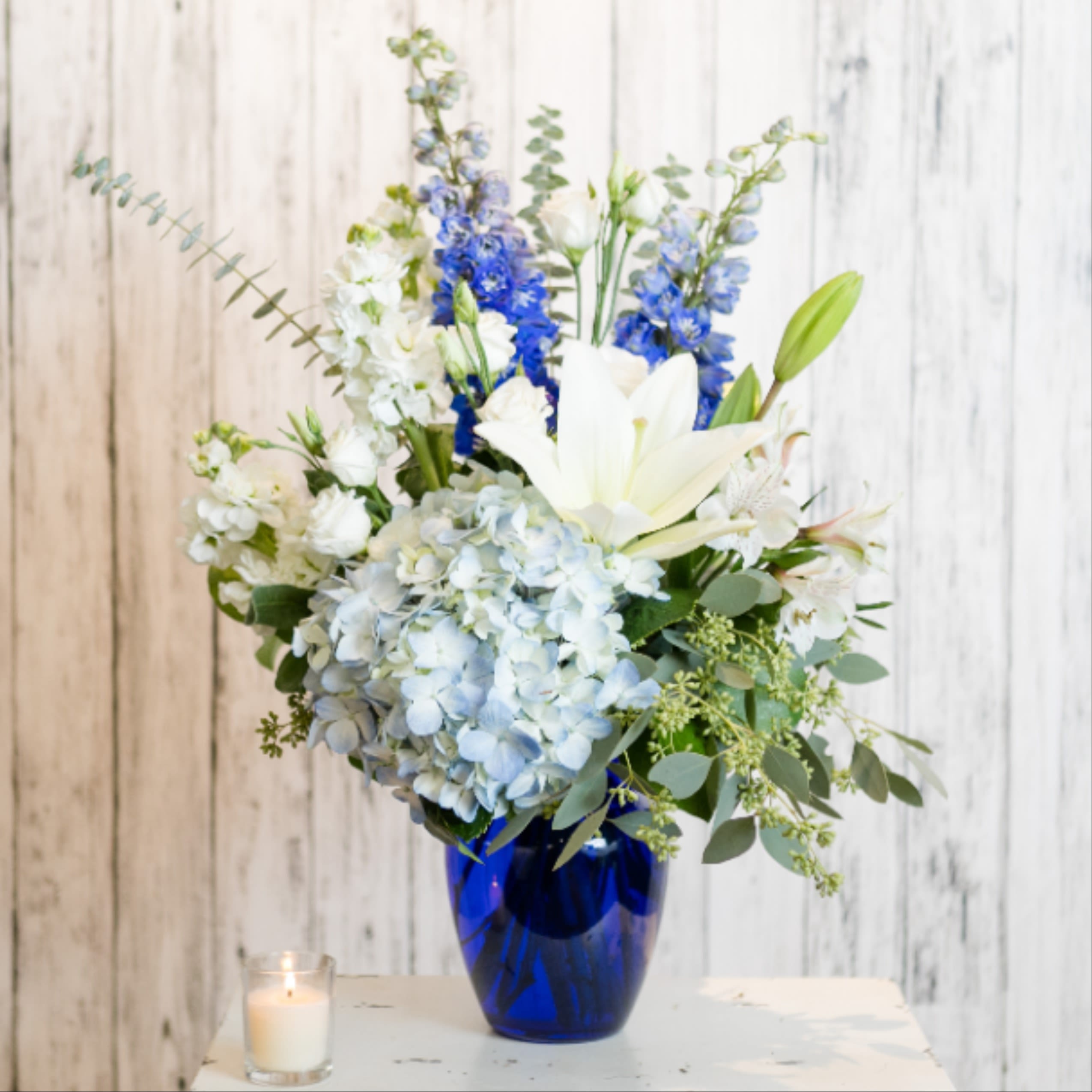Comfort - Classic blue and white blooms are presented in a cobalt vase.  Versatile and timeless!  Approx: 24" H x 14" W