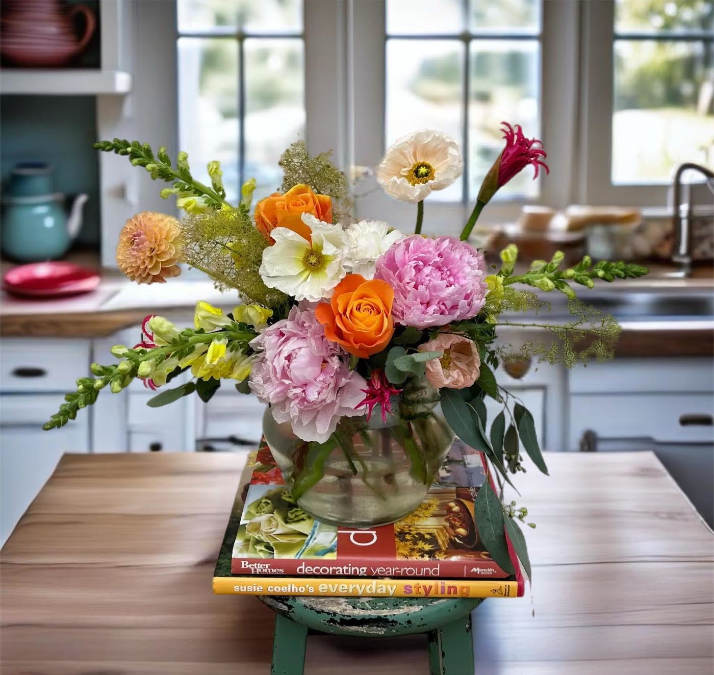 Mixed bouquet in a glass vase with orange, pink, and white blooms