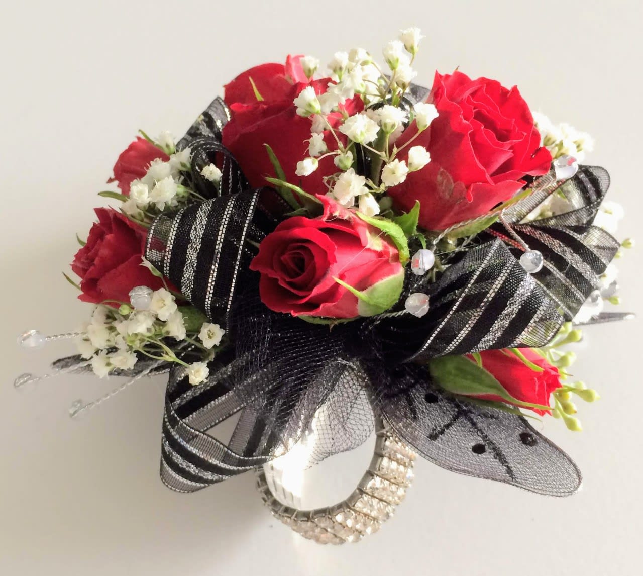Red roses with white baby's breath and black ribbon accents