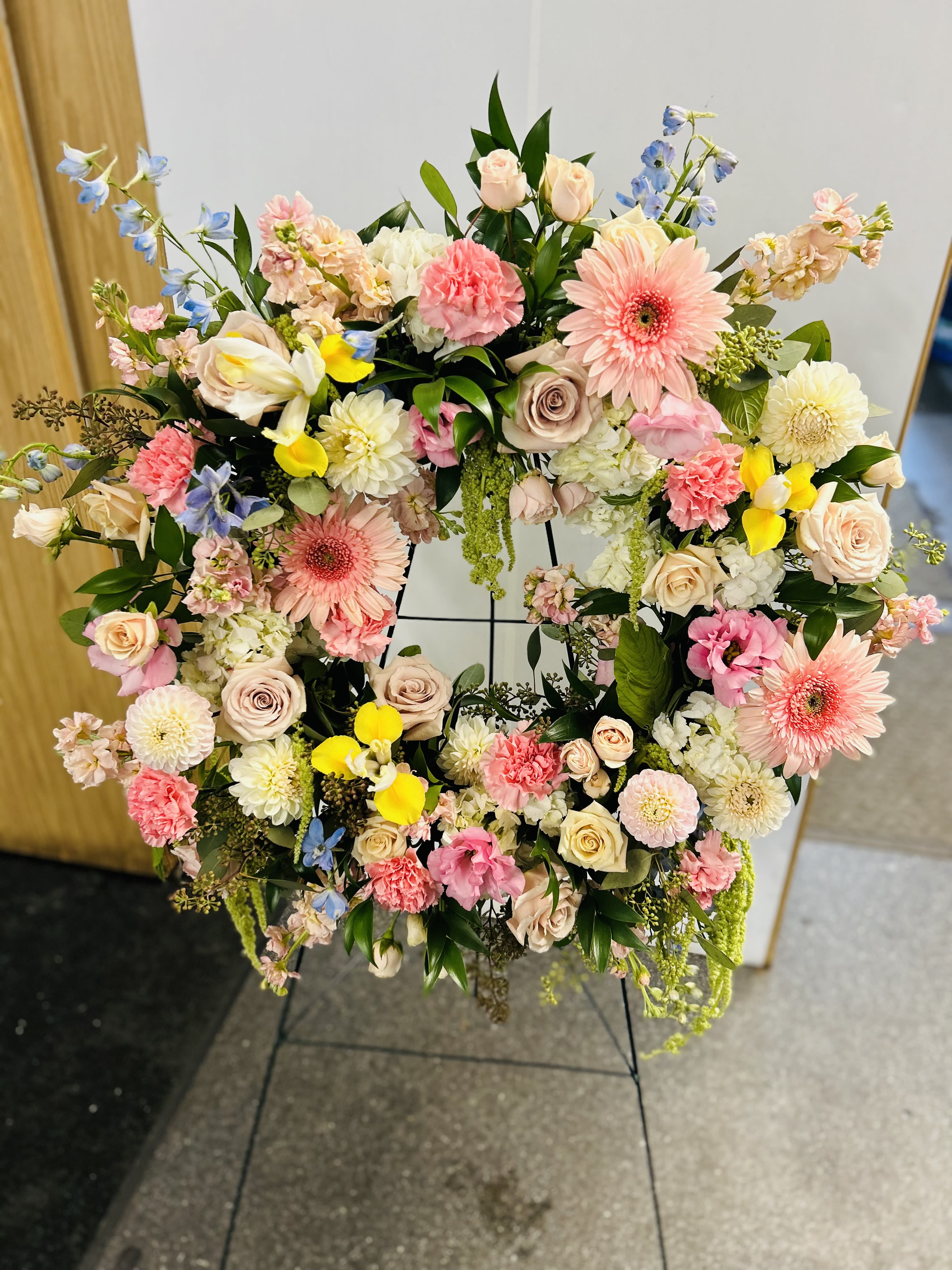 Large floral wreath with pink, cream, yellow, and blue flowers