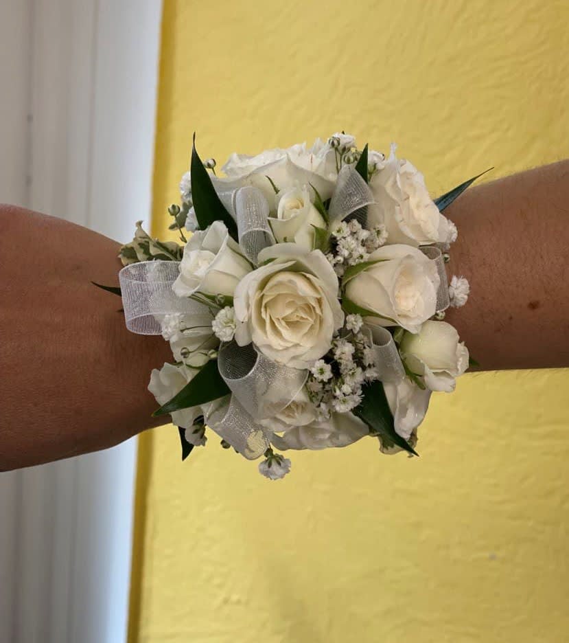 White rose wrist corsage with silver ribbon and green accents