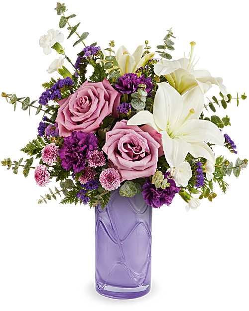 Mauvelous Bloom - Celebrate her sweetest moments with this beautiful bouquet in soft shades of purple, a dreamy mix of vibrant blooms beautifully arranged in Teleflora's Pretty Daydream Vase-a charming keepsake she'll enjoy long after Mother's Day. The arrangement features roses, carnations, miniature carnations, cushion spray chrysanthemums, sinuata statice, and limonium, accented with a succulent mix of greens. 
