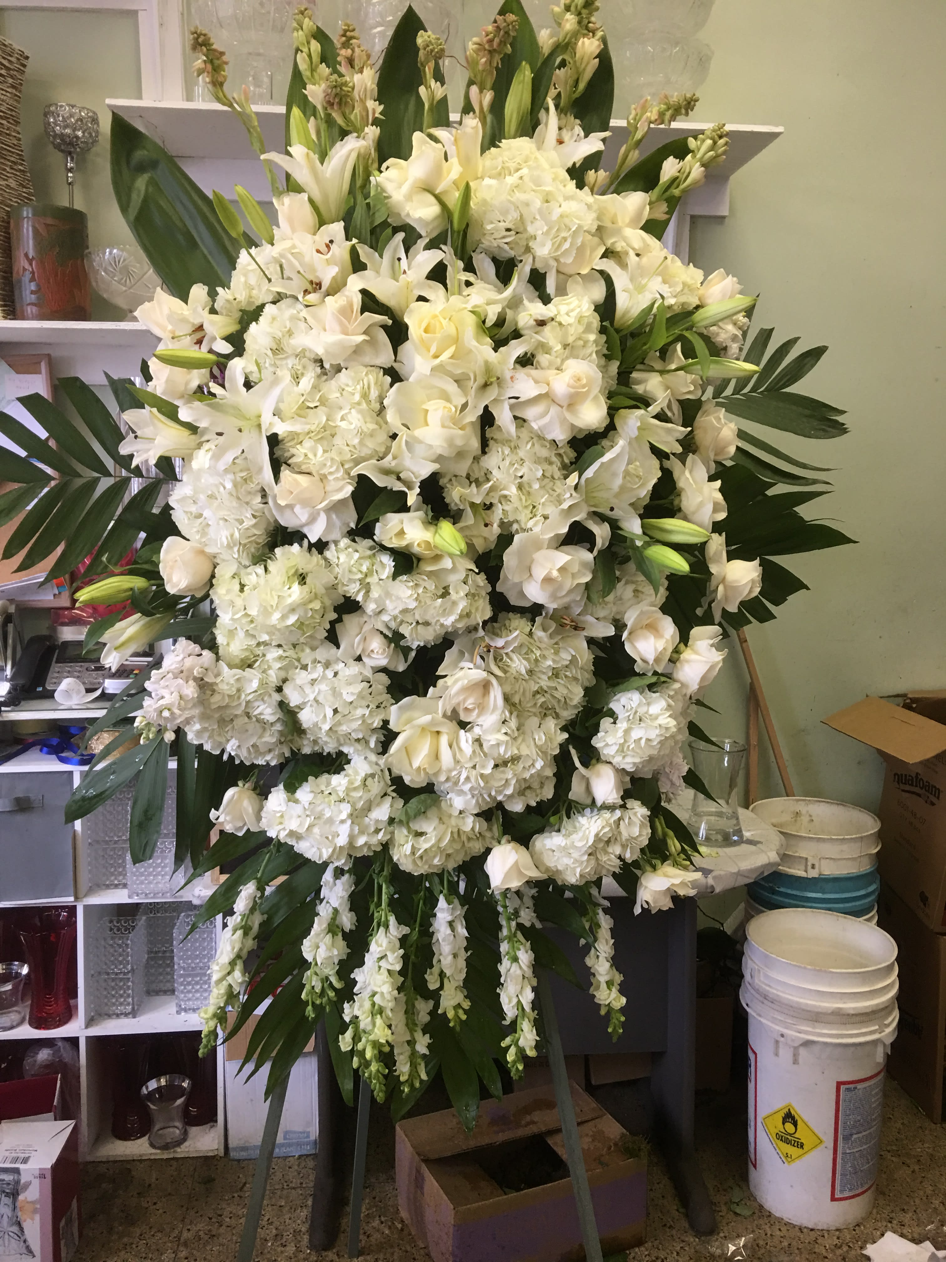 Large white funeral spray with lilies, roses, and hydrangeas