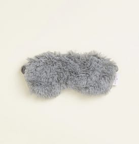 Gray fuzzy plush eye mask on a light background