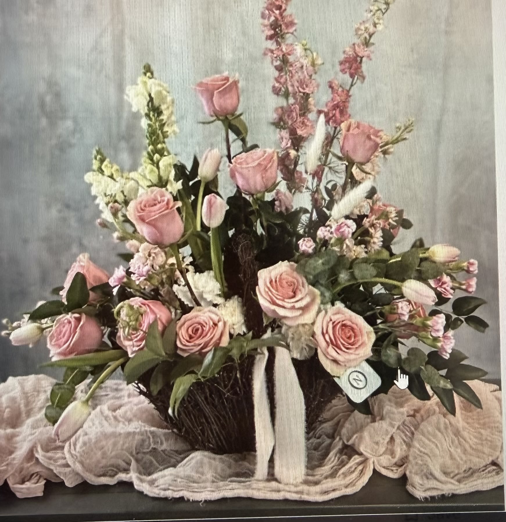 Heavenly Blush Arrangement - A graceful and sophisticated arrangement designed in soft blush and pastel tones, featuring elegant pink roses, delicate tulips, and seasonal blooms beautifully arranged in a natural woven basket. Accented with lush greenery and airy textures, this design creates a light, romantic feel perfect for any occasion.  Ideal for birthdays, anniversaries, sympathy, or simply to brighten someone’s day, this arrangement offers a timeless expression of beauty and care.  Handcrafted with fresh, high-quality flowers, each piece is uniquely designed to ensure a stunning presentation.