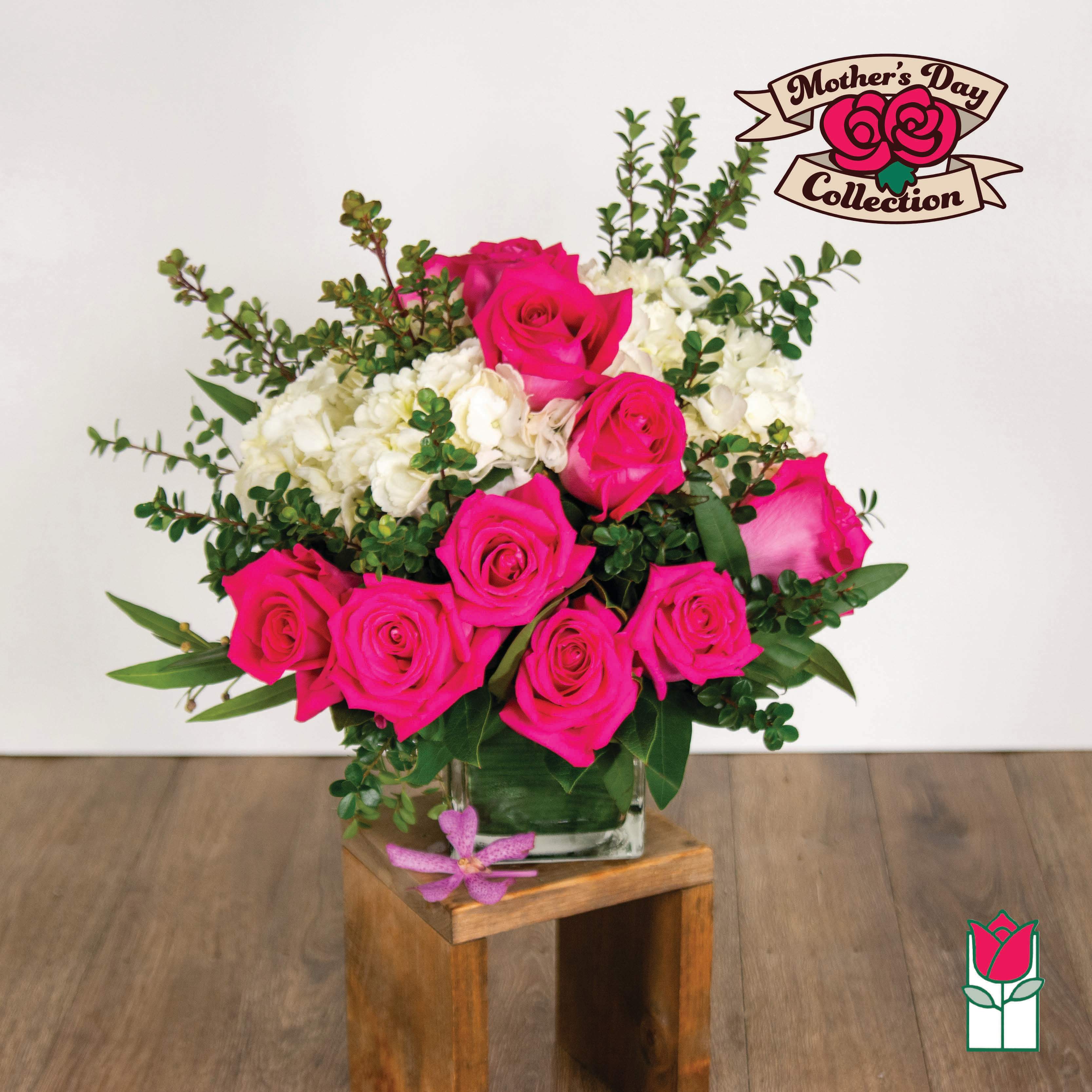 Pink roses and white hydrangeas in a glass vase with greenery