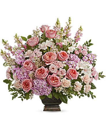 Teleflora's Feeling Loved Bouquet - Let them know just how loved they are with this awe-inspiring bouquet of pink blooms, beautifully presented in an elegant vase ( depending in store availability.)  This arrangement includes pink hydrangea, pink roses, pink spray roses,  alstroemeria, light pink carnations,  snapdragons,  stock, pink waxflower, huckleberry, lemon leaf and variegated pittosporum.  Orientation: One-Sided