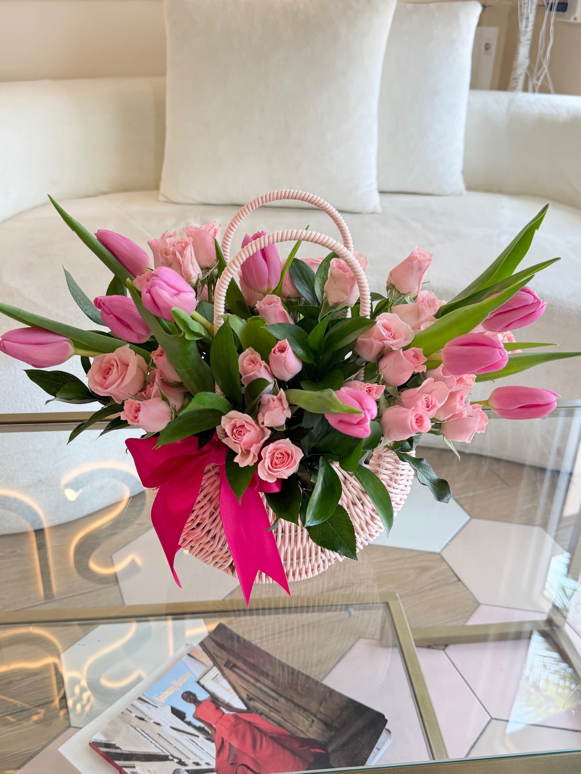 Pink Mix - A full, balanced mix of pink tulips and spray roses paired with fresh greenery, arranged low and lush in a woven basket. Finished with a clean ribbon detail, this piece feels effortless, polished, and easy to gift—perfect for everyday moments or a simple, elevated gesture.