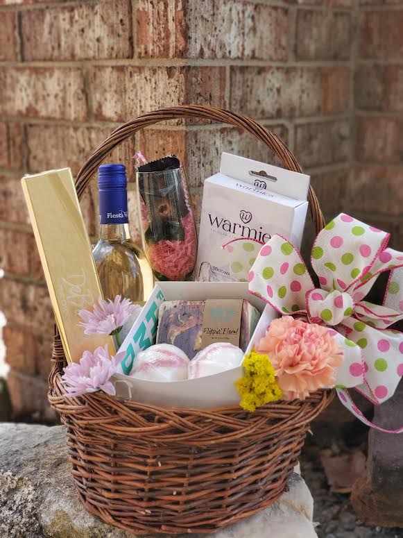 Gift basket with wine, chocolates, bath items, and flowers