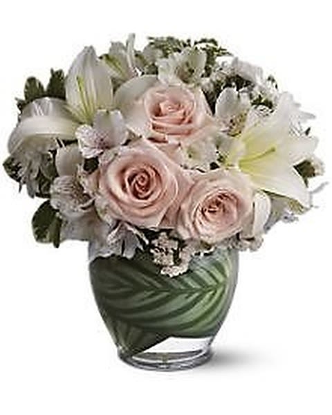 Enchanted Evening - This fragrant blend of crème and white blossoms is an enchanting vision of floral beauty. It’s as soft and pretty as a cloud! A leaf-lined vase adds a special touch to this stunning bouquet that’s appropriate for any special occasion.