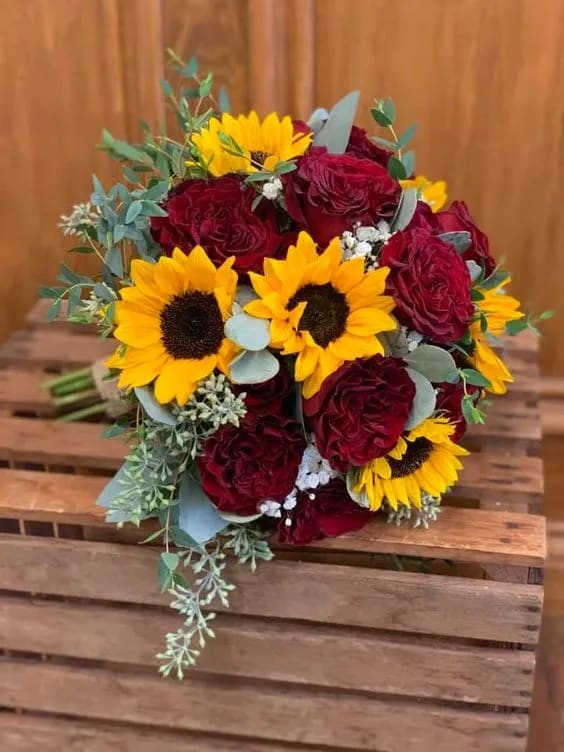 Bouquet of red roses and yellow sunflowers with eucalyptus