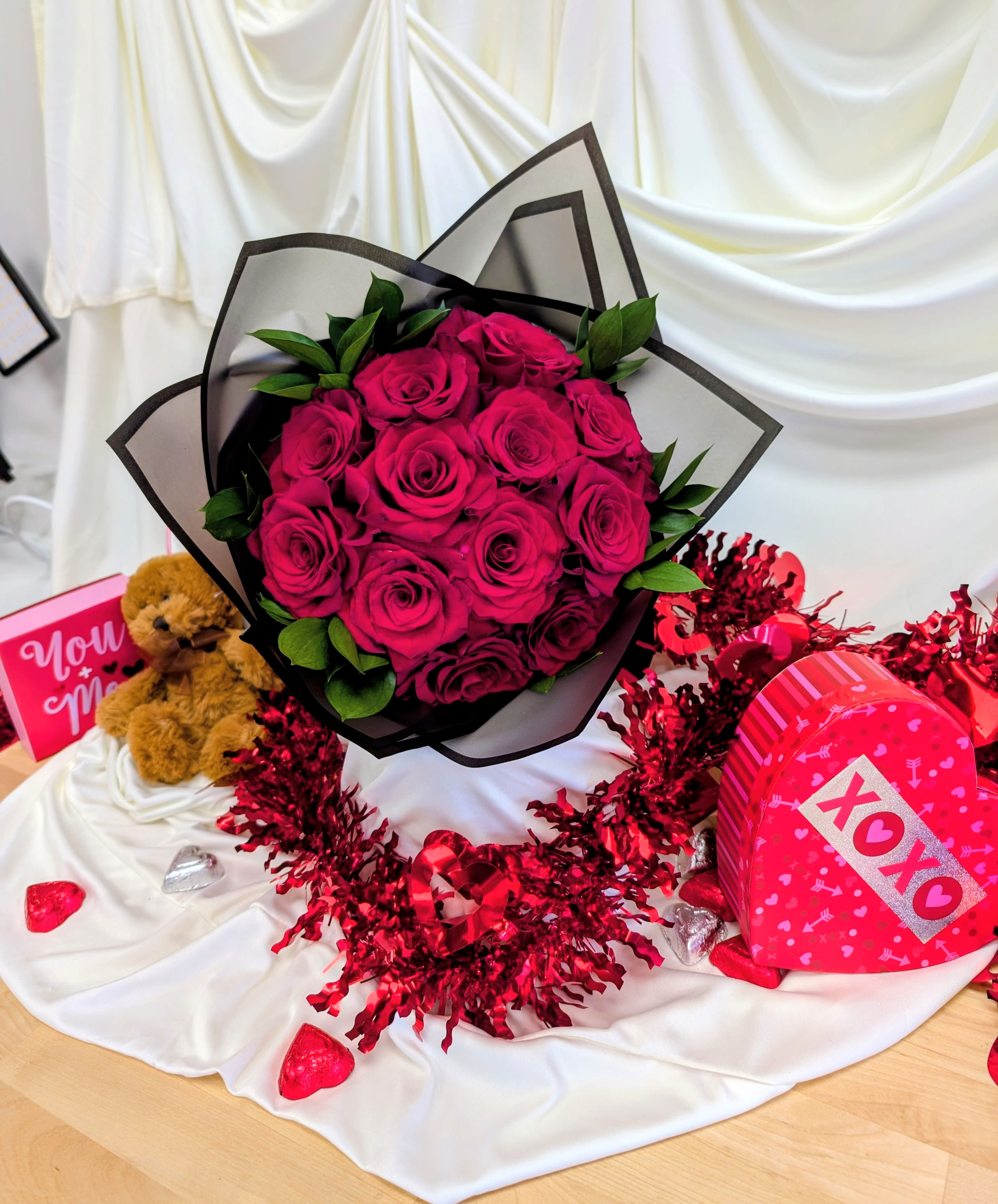 Bouquet of hot pink roses with a teddy bear and heart-shaped gift boxes
