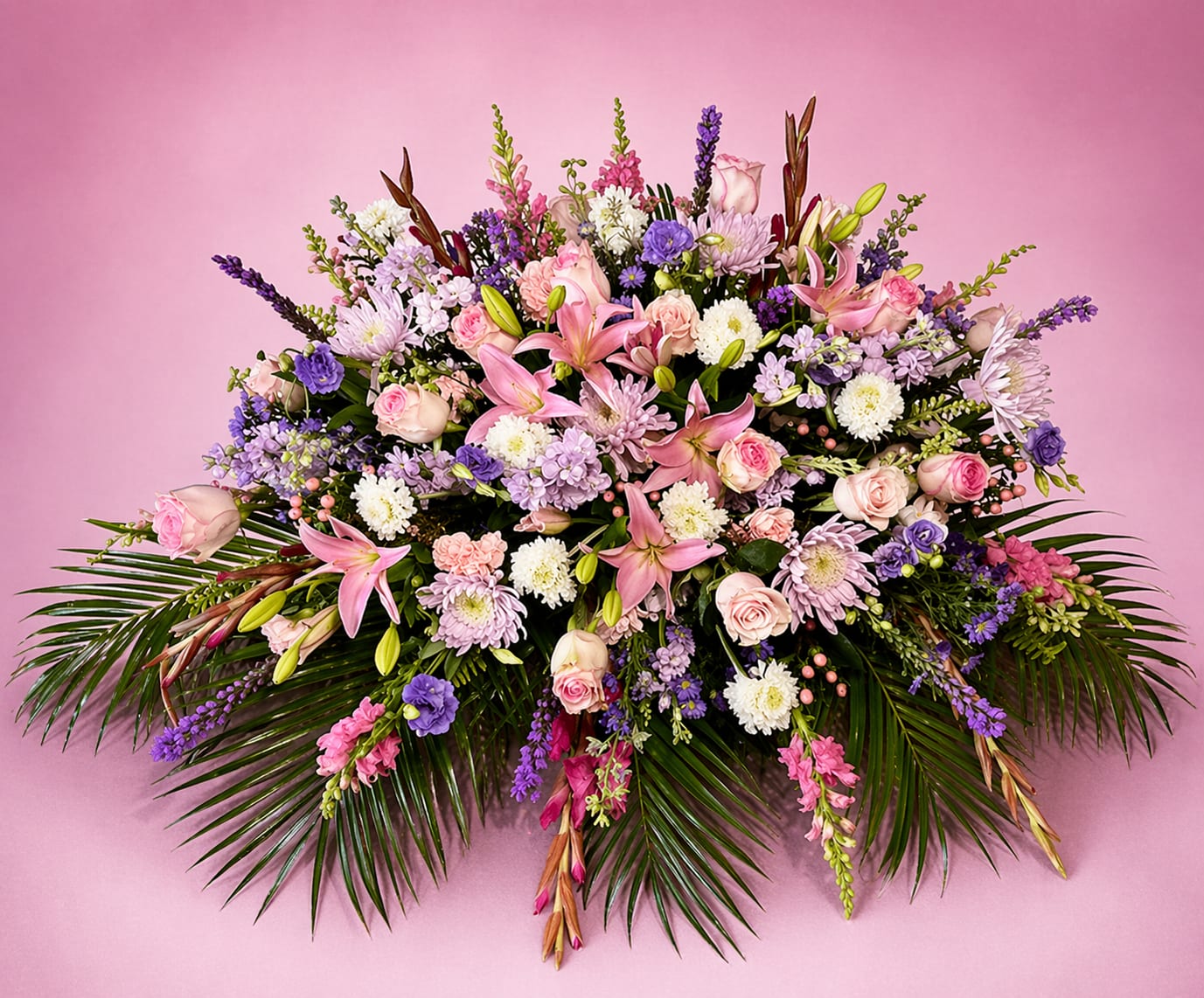 Large pink and purple floral arrangement with lilies, roses, and chrysanthemums