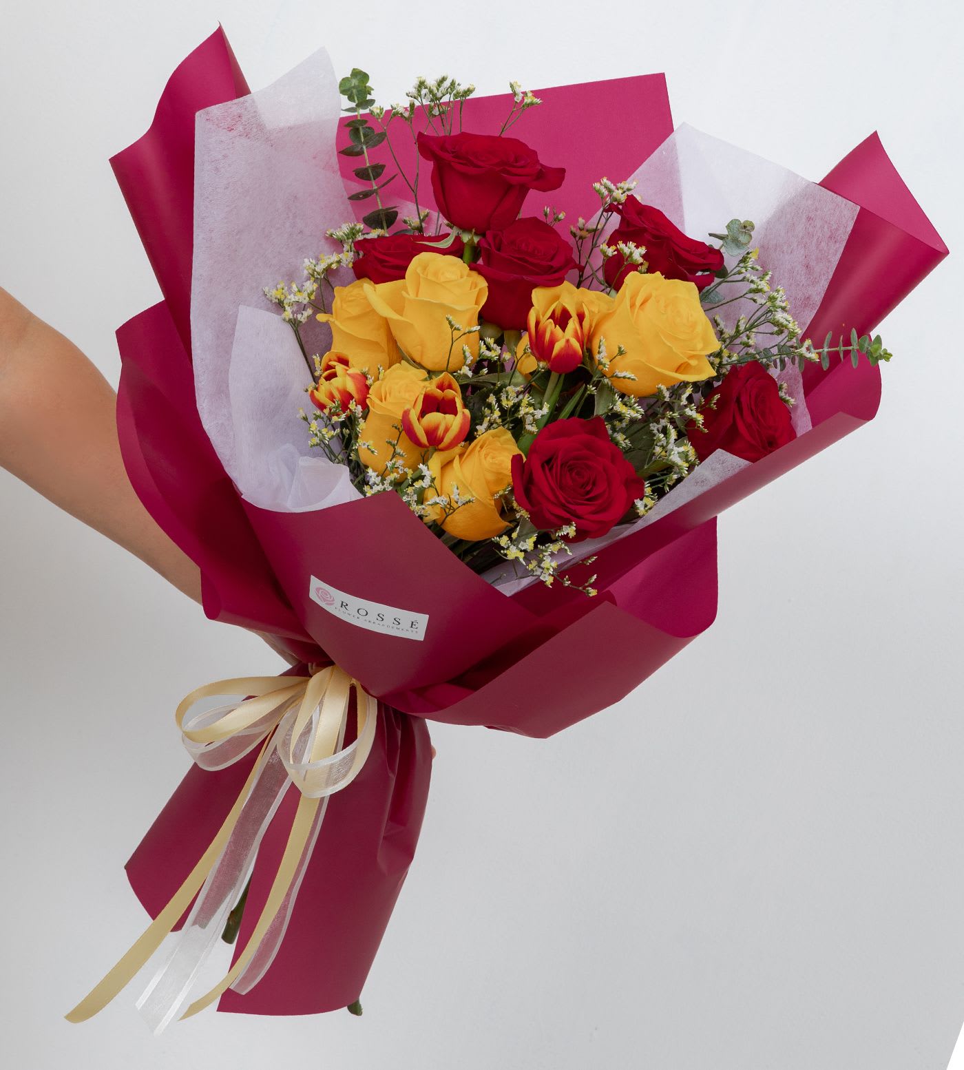 Cardinal &amp; Gold - A vibrant bouquet featuring a dozen roses paired with fresh tulips and accented with cheerful yellow filler flowers. Bright and elegant, this arrangement is perfect for celebrations, graduations, or a joyful surprise.  Flower types may vary depending on the season.