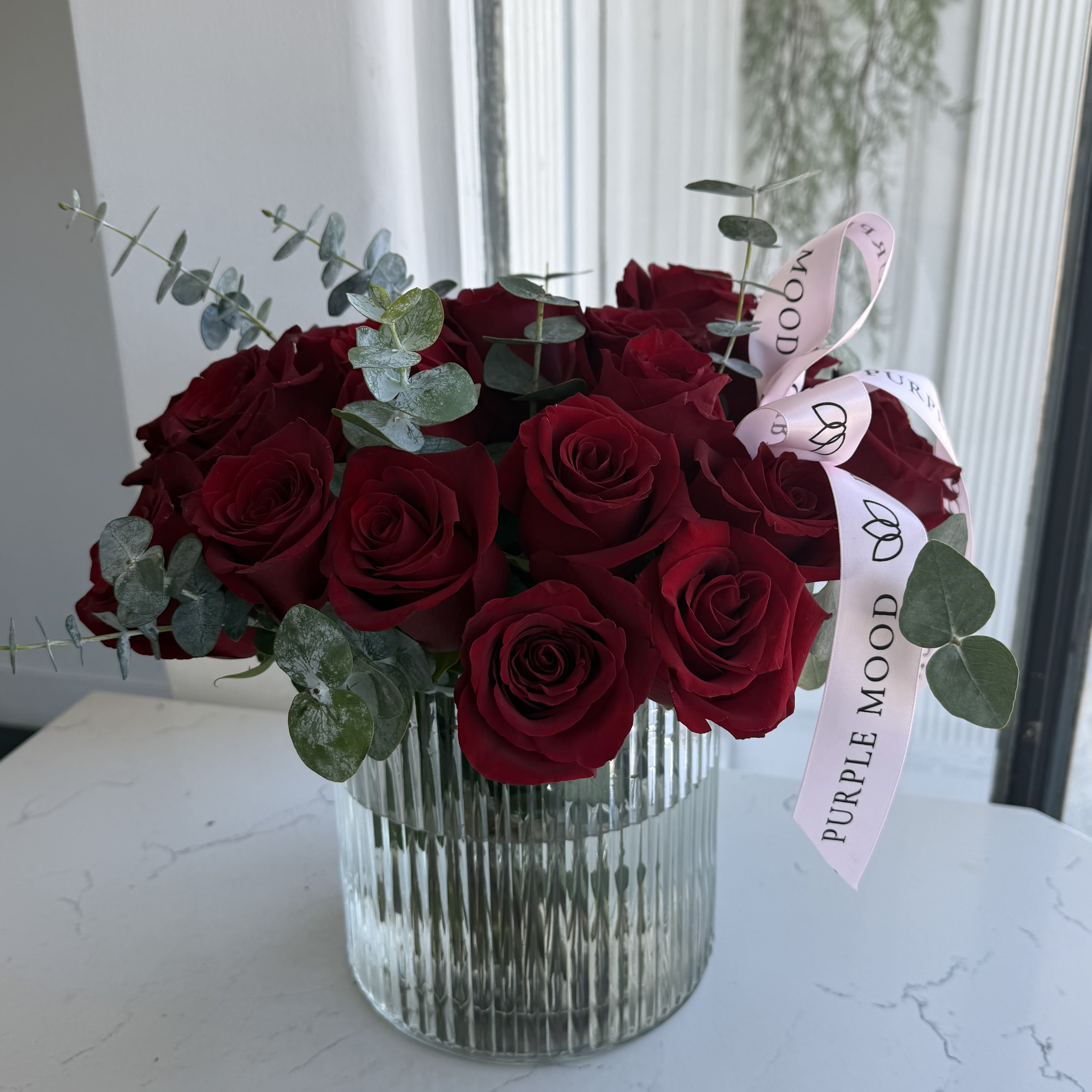 25 Red Roses Vase - Classic red roses with eucalyptus in a modern vase — elegant, romantic, and made to express love.
