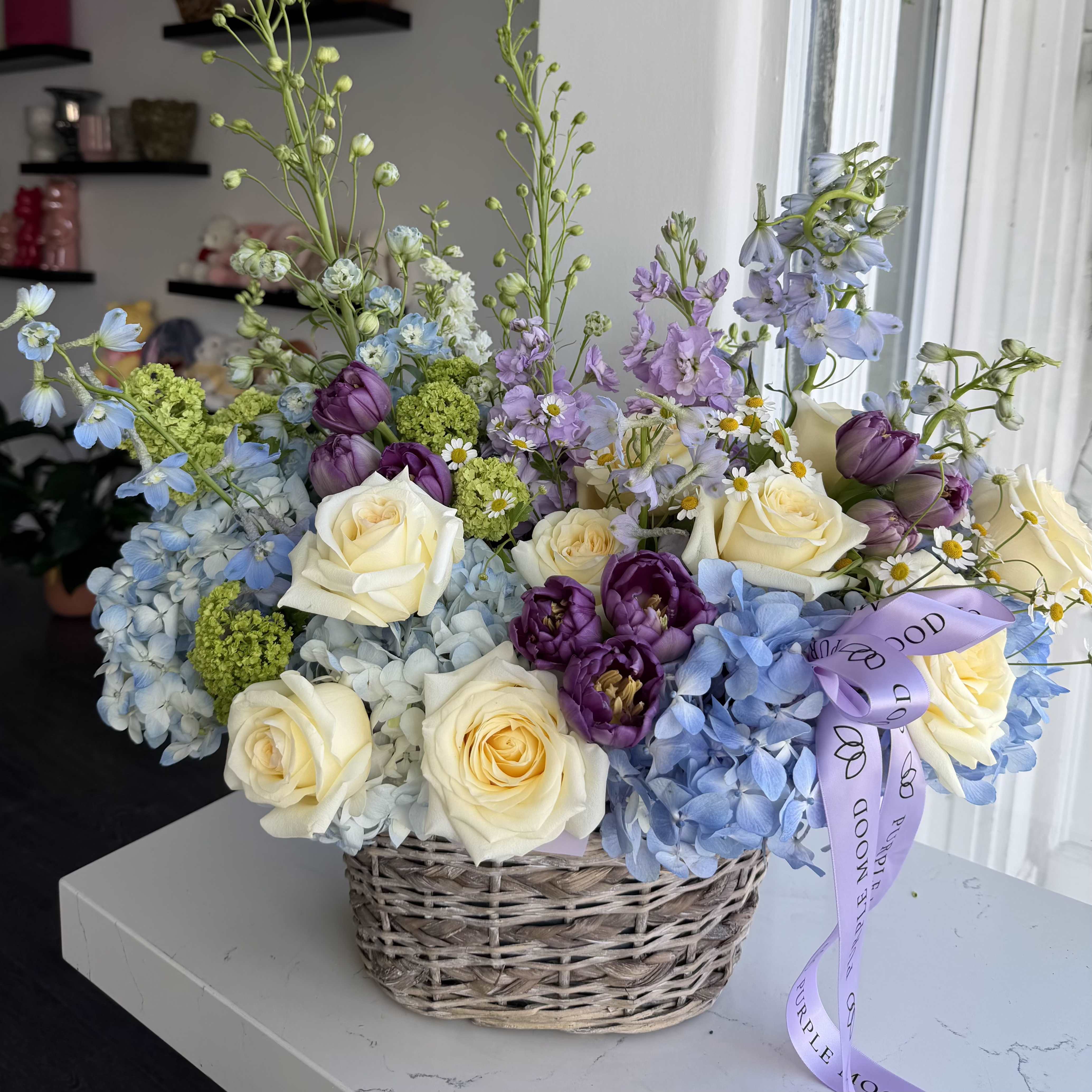 Soft Love Basket - A luxurious basket arrangement featuring roses, hydrangea, tulips, and premium seasonal flowers in soft pastel shades. Full, airy, and beautifully textured, this design brings a gentle, romantic feel — perfect for expressing love and appreciation.