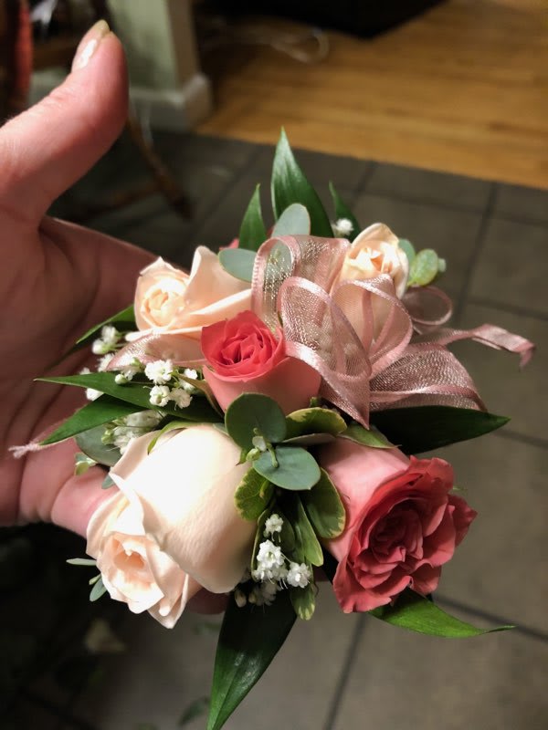 Small hand-tied bouquet of pink and cream roses with ribbon